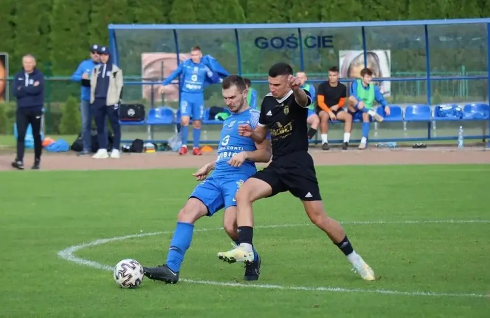 Mateusz Mucha walczy o piłkę podczas meczu Kani Gostyń
