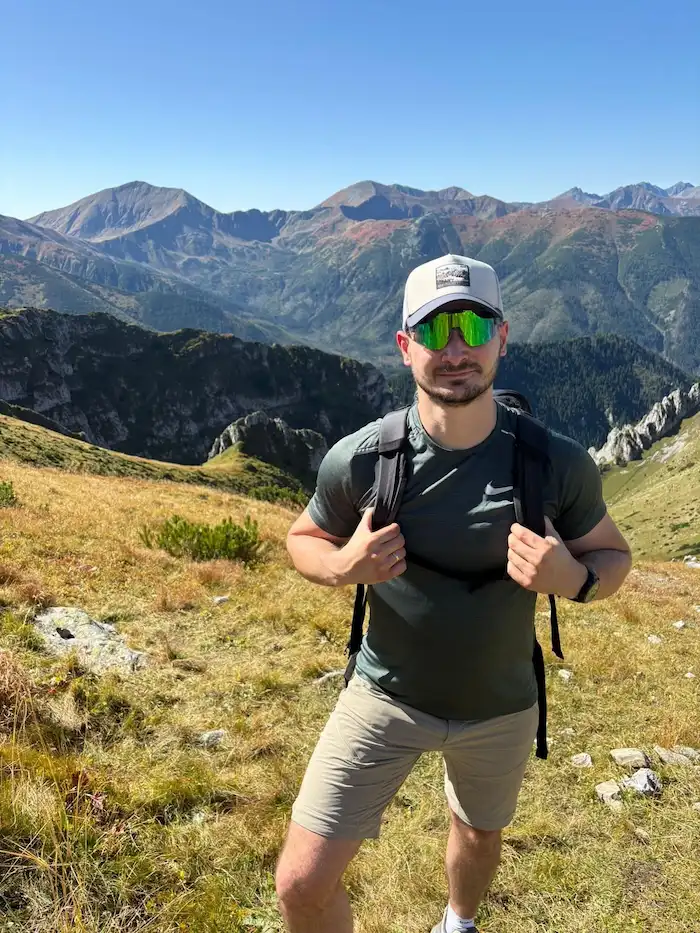 Mateusz Mucha na górskim szlaku z panoramą Tatr w tle