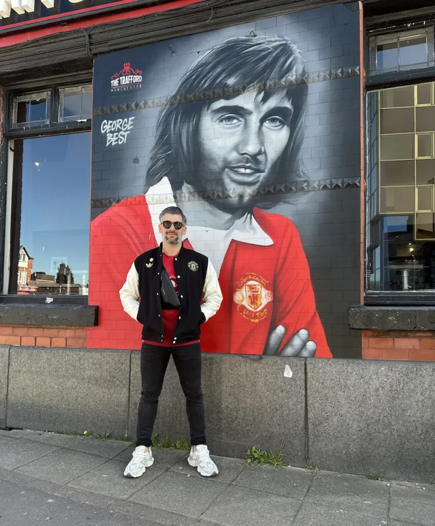 Robert Przewoźny przed muralem George’a Besta w Manchesterze