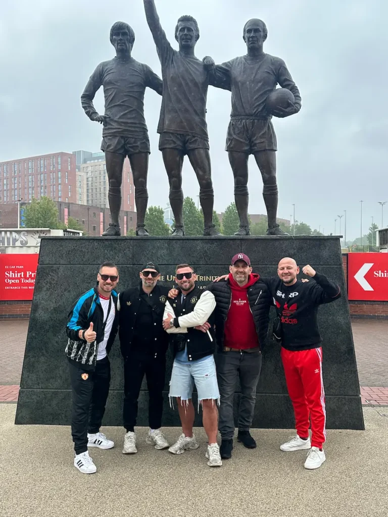 Robert Przewoźny z grupą znajomych przed pomnikiem United Trinity przy stadionie Old Trafford