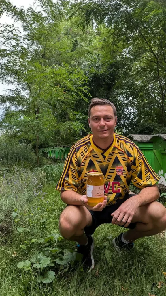 Tomasz Piotrowiak z miodem z rodzinnej pasieki Tommy w koszulce Arsenalu